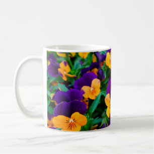 Schöne blühende Stiefmütterchen im Garten Kaffeetasse