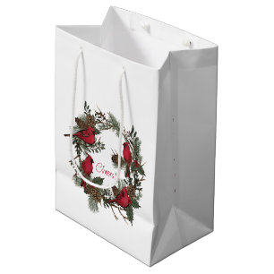 Schöne rote Kardinäle in einem Weihnachtskranz Mittlere Geschenktüte