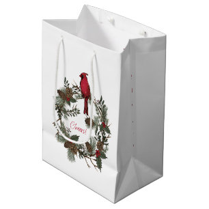 Schöne rote Kardinäle in einem Weihnachtskranz Mittlere Geschenktüte