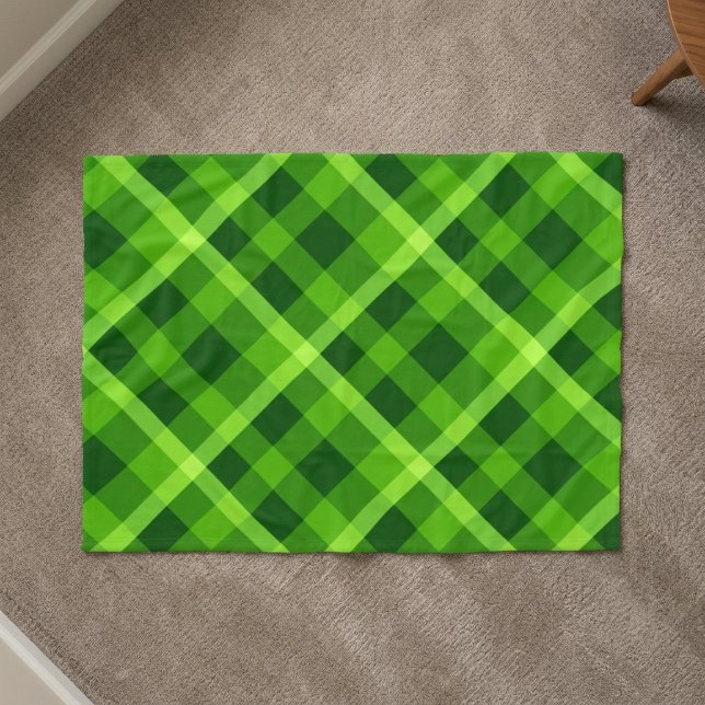 Schöner grüner Baum Karo kleine Fleece-Decke Fleecedecke (Top down view of Beautiful Tree Green Plaid Small Fleece Blanket on a carpet floor in a home.)
