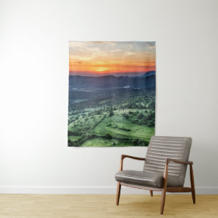 Schöner Sonnenuntergang hinter grünen Feldern Wandteppich