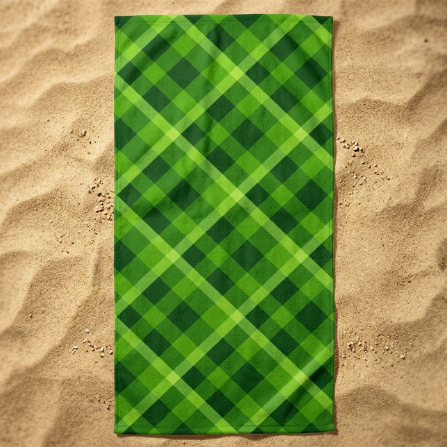 Schönes Kariertes Strandtuch mit Baumbestand (Beautiful Tree Green Plaid Beach Towel laid out on beach sand.)