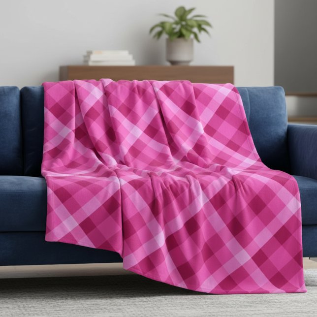 Schönes Pink Magenta Kariert große Fleece Blanka (Beautiful Pink Magenta Plaid Large Fleece Blanket draped on a blue sofa in a living room.)