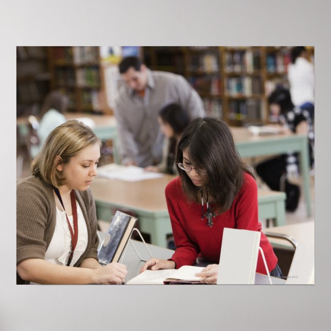 Schüler, die in der Schulbibliothek mit Bibliothek Poster (Vorne)