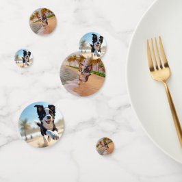 Schwarz-Weiß-Hund läuft am Strand Konfetti