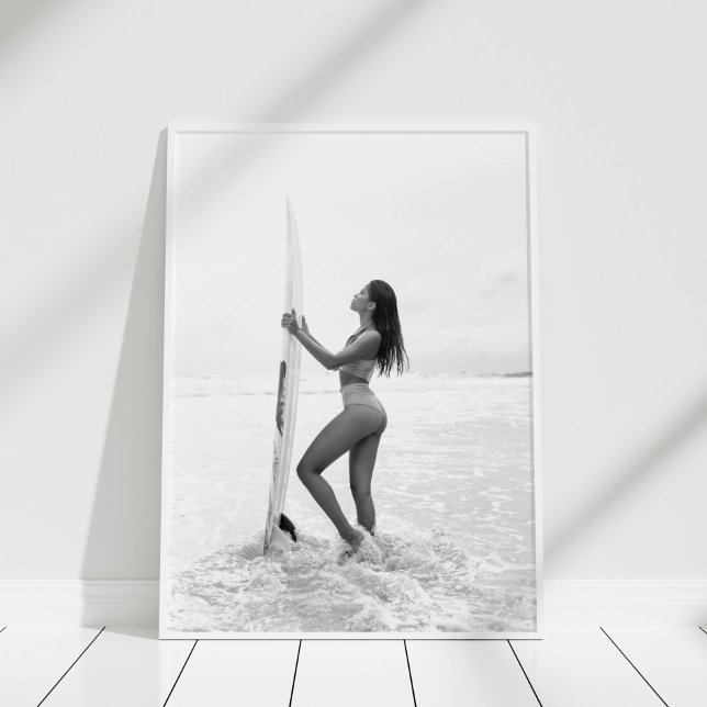 Schwarz-Weiß-Surfer-Girl am Strand Poster (Black and White Surfer Girl on the Beach Poster in white frame on wooden floor.)