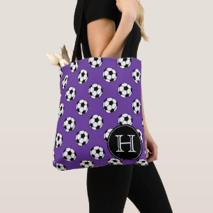 Schwarz-weiße Fußbälle auf violettem Monogramm