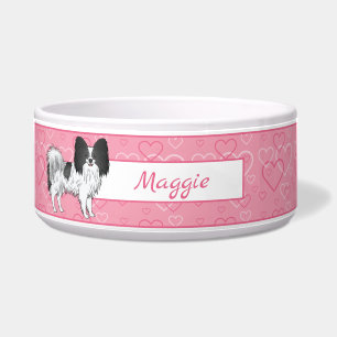 Schwarz-weißer Papillon-Hund auf rosa Herzen Napf