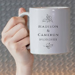 Schwarz-weißes elegantes Hochzeitsstichtag für Blä Kaffeetasse<br><div class="desc">Das elegante Schwarz-Weiß-Hochzeitskaffee-Design zeichnet sich durch die Namen des Ehepaares und das Veranstaltungsdatum in einem schönen klassischen Serif-Schriftart aus, der in edlem Schwarz auf einem knusprigen, weißen Hintergrund gehalten ist. Die traditionelle, frische Komposition wird mit dekorativen botanischen Blätter geschmückt. Design wiederholt sich so, dass es sichtbar ist, wenn es in...</div>