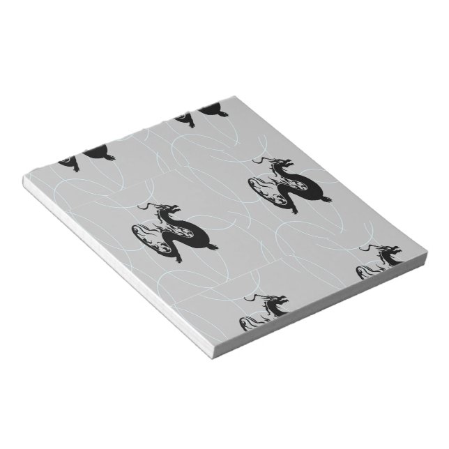 Schwarze Drachen auf grau Notizblock (angewinkelt)