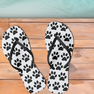Schwarze Hundepfotenabdrücke auf Weiß Flip Flops