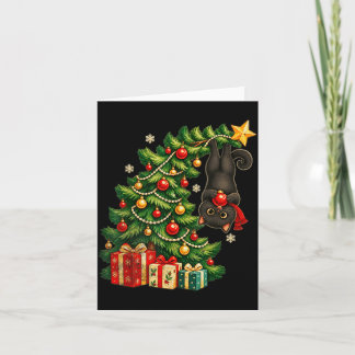 Schwarze Katze hängt am Weihnachtsbaum festliches Karte
