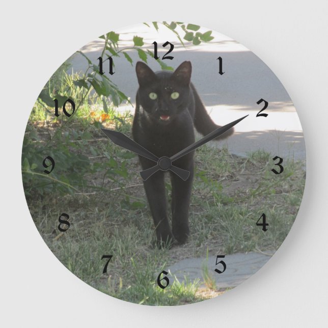 Schwarze Katze in einem Garten Große Wanduhr (Vorderseite)