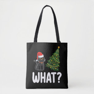 Schwarze Katze schiebt Weihnachtsbaum lustig