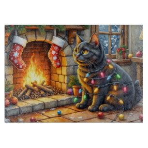 Schwarze Katze sitzt am Kamin mit Weihnachtslichte Schneidebrett