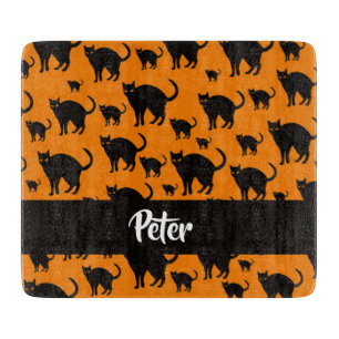 Schwarze Katzen auf Orange Schneidebrett