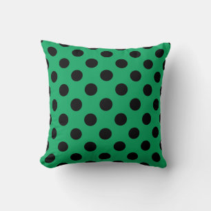Schwarze Polka Punkte auf frisch grünem Kissen