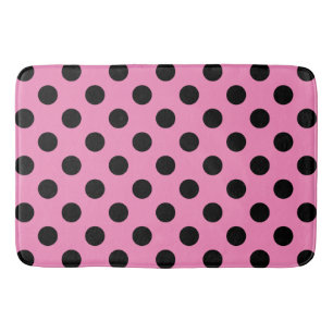 Schwarze Polka-Punkte auf Rosa Badematte