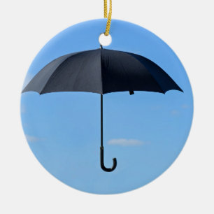 Schwarzer Regenschirm fliegt am blauen Himmel Keramikornament