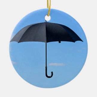 Schwarzer Regenschirm fliegt am blauen Himmel Keramikornament