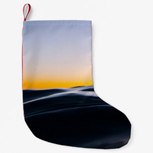 SCHWARZER SAND UNTER ORANGEFARBENEM HIMMEL BEI SON KLEINER WEIHNACHTSSTRUMPF