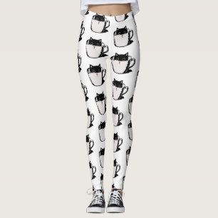 Schwarzes Kätzchen mit roter Nase, das sich in ein Leggings