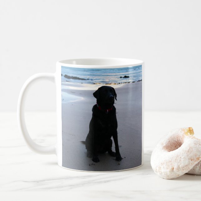 Schwarzes Labrador auf einem Strand Tasse (Mit Donut)