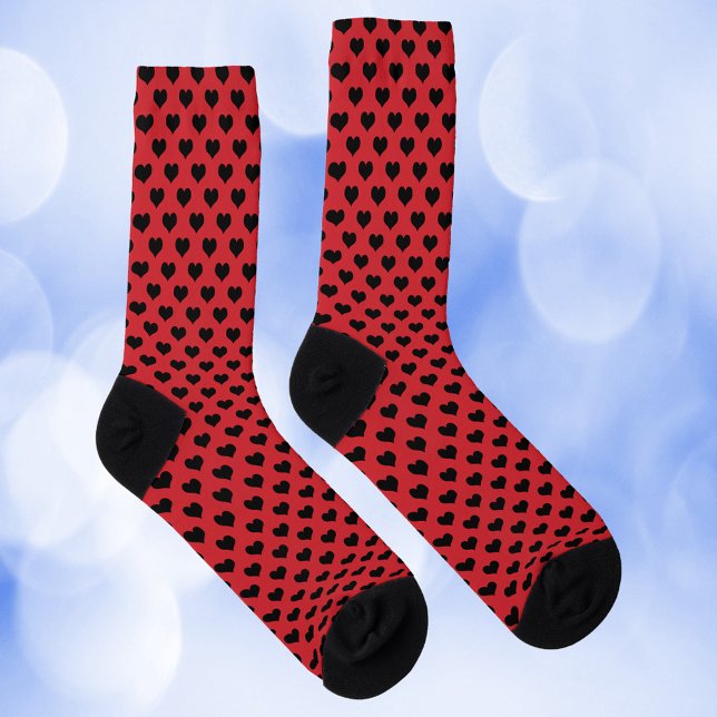 Schwarzes Muster auf rotem Hintergrund Socken (A pair of socks with black hearts on a red background)