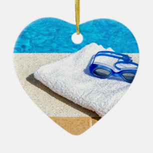 Schwimmenschutzbrillen und -tuch nahe Swimmingpool Keramikornament