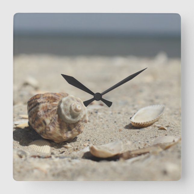 Seashells auf Sand durch das Meer Quadratische Wanduhr (Vorderseite)
