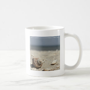Seashells auf Sand durch das Meer Tasse