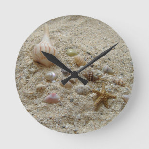 Seashells Nestled in Beach Sand Runde Wanduhr