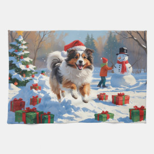 Shetland Sheepdog läuft durch Schnee mit Weihnacht Geschirrtuch