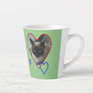 Siamkatze in Herzkruste. Grüne Latte-Tasse Milchtasse