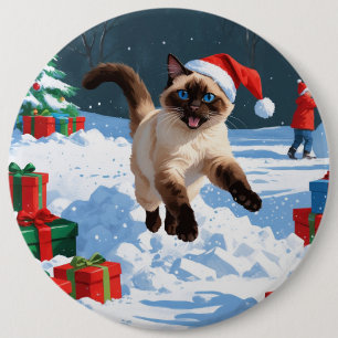 Siamkatze läuft im Schnee mit Weihnachtsmütze Button