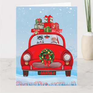 Sibirischer Husky-Hund in Auto mit dem Weihnachtsm Karte