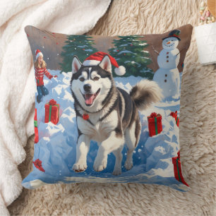Sibirischer Husky läuft im Schnee mit Weihnachtsmü Kissen
