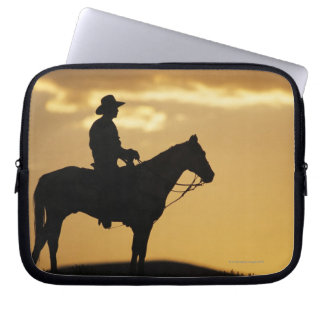 Silhouette des Cowboys auf Pferden bei Sonnenunter Laptopschutzhülle