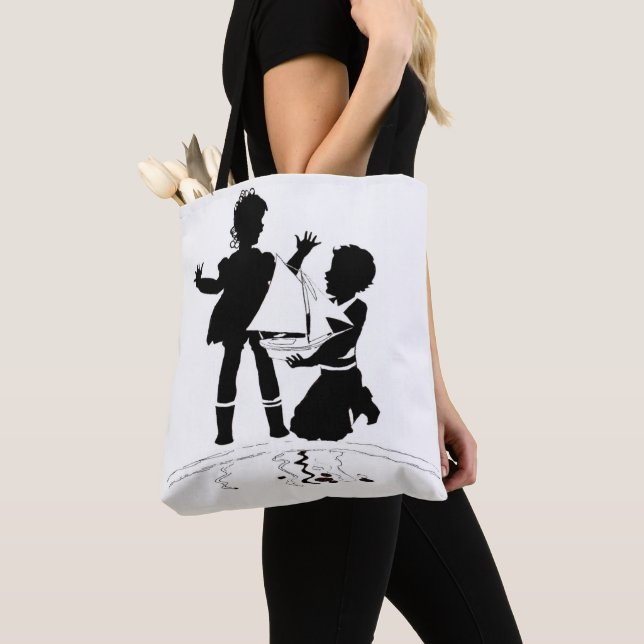 Silhouette von Mädchen und Jungen und Modellschiff (Von Nahem)