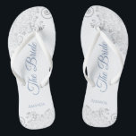 Silver Lace & Dusty Blue Script The Bride Wedding Flip Flops<br><div class="desc">Tanzen Sie die Nacht mit diesen schönen Hochzeitsflip-Flops. Sie sind für die Braut konzipiert und zeichnen sich durch ein schlichtes, aber elegantes Design aus, das auf weißem Hintergrund mit staubblauen Schriftzeichen und extravaganten silbergrauen Spitzen-Gürteln und Wirbel versehen ist. Eine schöne Art, extravagant und angemessen bleibe, während Sie Ihren Füßen eine...</div>