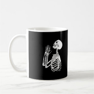Skelett, das auf einer kaffeetasse