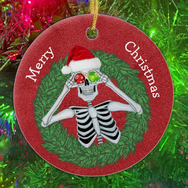 Skelett in Pine Christmas Wreath Red Hat Funny Keramik Ornament (Fun Skeleton With ornaments in pine Wreath on Red ceramic Christmas tree ornament.)