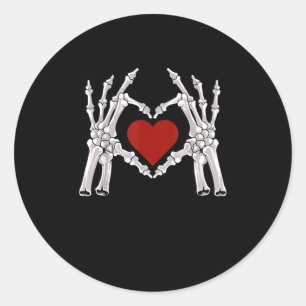 Skeletthandschuhe formen ein Herz mit rotem Herzen Runder Aufkleber