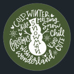 Snowman Christmas Winter Wonderland Typografie Runder Aufkleber<br><div class="desc">Eine festliche typografische Komposition von handgeschriebenem Weihnachtszitat (Schneekill, Steinglocken, Kalter Winter, Weiße Weihnachten, Wunderland, Weihnachtswunsch) umkreist einen Schneemann mit kleinen Herzen und Schneeflocken. Ideal, um Weihnachts- und Feiertagsbriefe und Weihnachtskarten zu Siegel oder Ihre Geschenke unter dem Weihnachtsbaum zu schmücken! Forest Green Farbe ist vollständig veränderbar, auch die Farbe Weiß ist...</div>