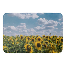 Sonnenblumenfeld unter blauem Himmel mit Wolken Badematte