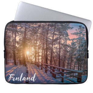 Sonnenuntergang im schneebedeckten Pinienwald mit Laptopschutzhülle