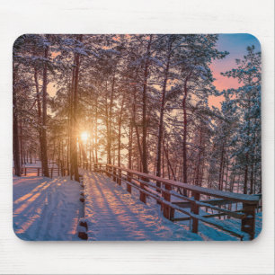 Sonnenuntergang im schneebedeckten Pinienwald mit Mousepad