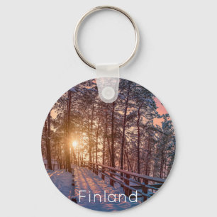 Sonnenuntergang im schneebedeckten Pinienwald mit Schlüsselanhänger
