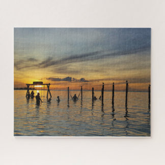 Sonnenuntergang mit Holzpfosten im Wasser Puzzle