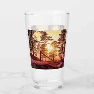 Sonnenuntergang über einem Holzweg im Kiefernwald Glas